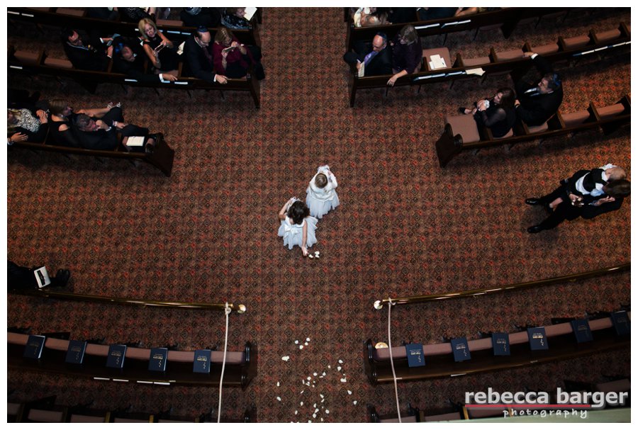 what an interesting photo of the flower girls heading down the aisle at Logan + Yoni's wedding ceremony at Rodeph Shalom.