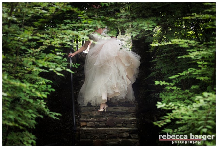 Becca comes down the stairs carrying all of her gown.